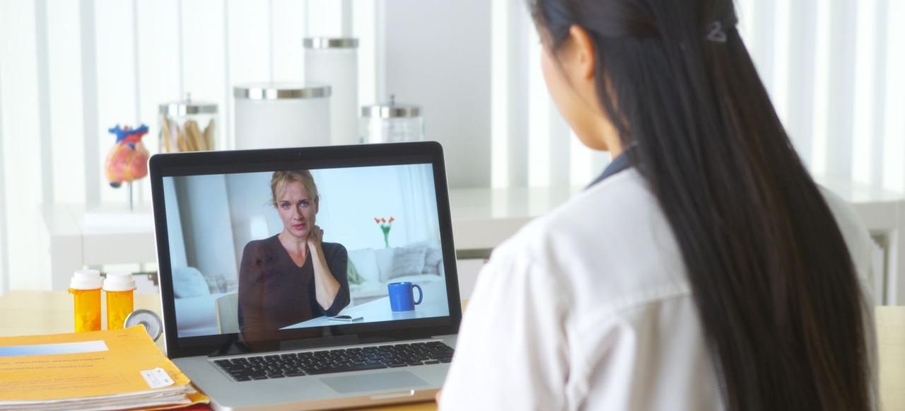 Chinese doctor video chatting with elderly patient